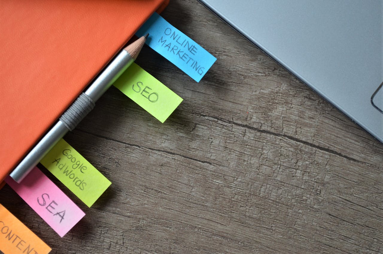 services-04 Close-up of SEO strategy planner with colorful sticky notes and a pencil on a notebook.
